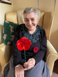 Female resident holding handmade poppy