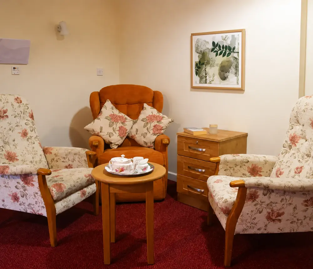 Communal lounge with comfortable seating at Ladymead Nursing Home in Swindon