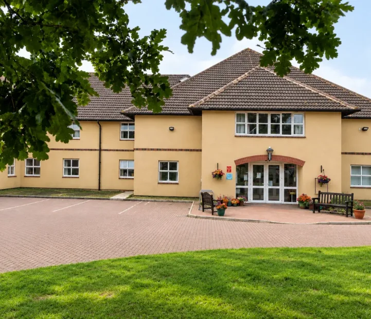 Exterior of Oaktree care home in Yate, Bristol, with landscaped grounds and visitor parking.