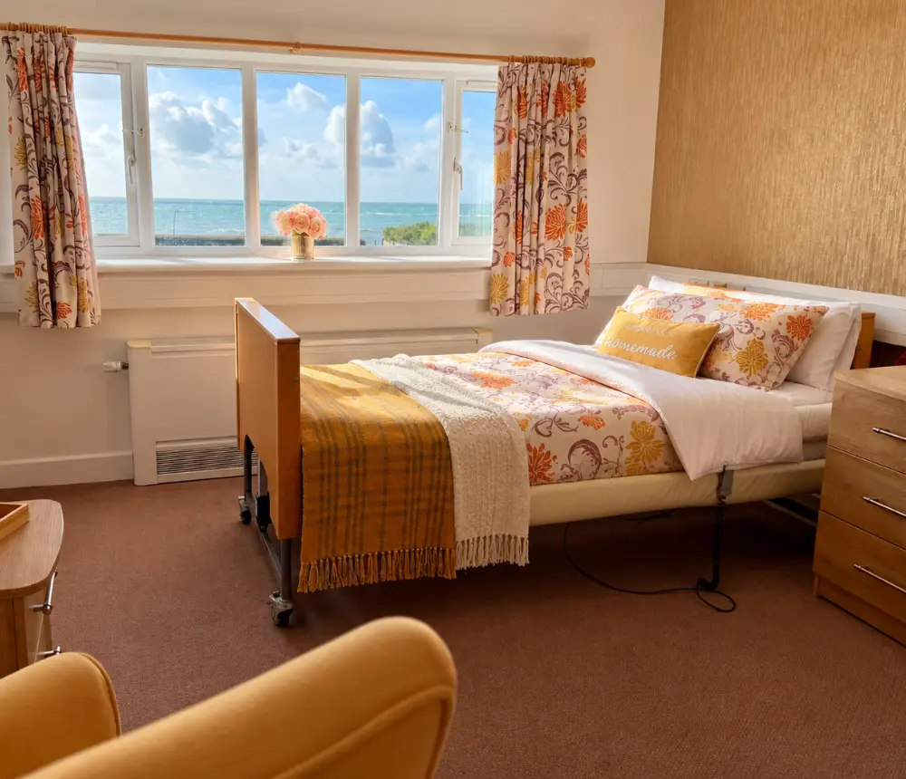 Comfortable bedroom overlooking the sea at Tenchley Manor nursing care home in Chichester.