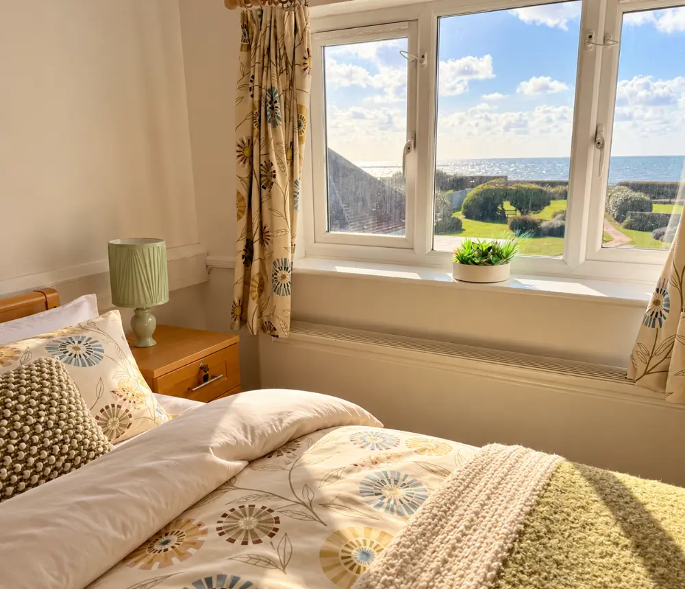 Furnished bedroom with sea views at Tenchley Manor residential and nursing care home in Chichester.
