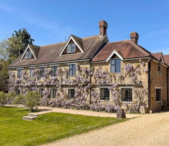 Exterior of The Malthouse care home in Gillingham with wisteria-covered stone walls and gardens.