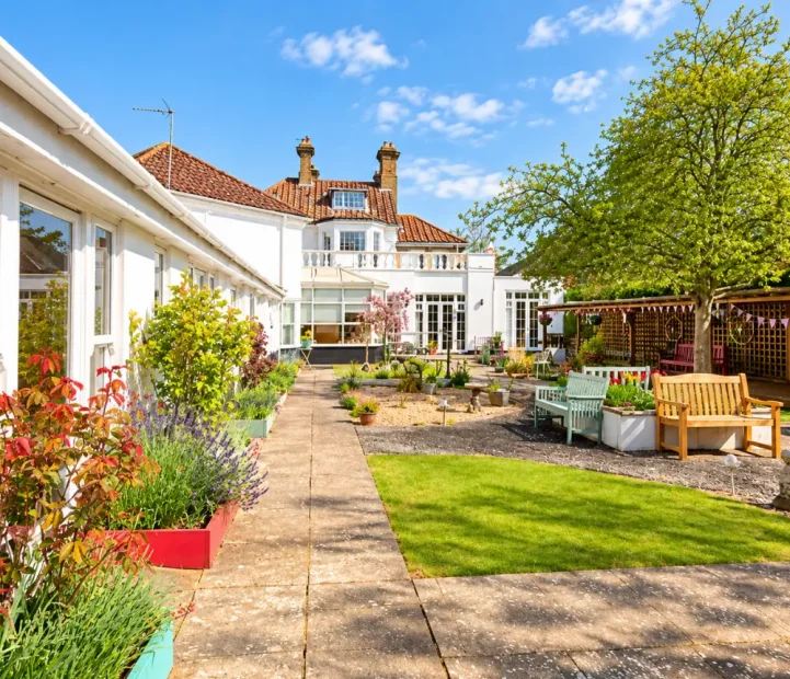 Landscaped garden with outdoor seating at The White House care home in Beccles.