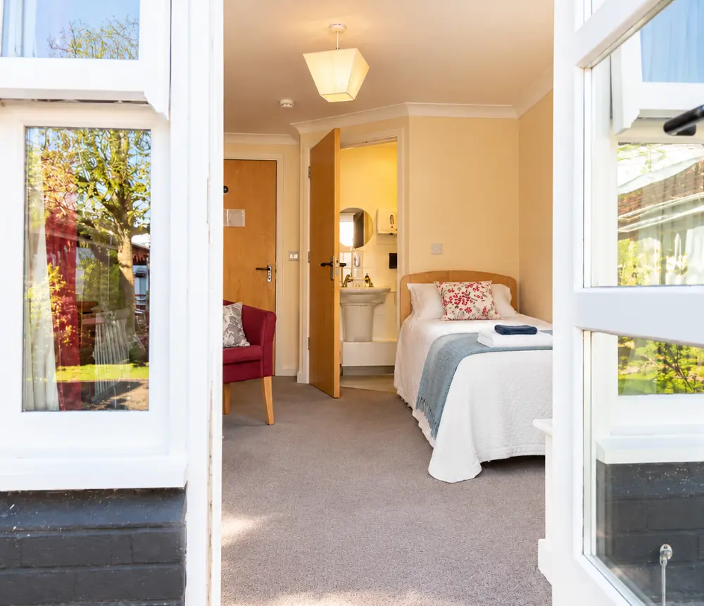 Comfortable single bedroom with garden access at The White House care home in Beccles.