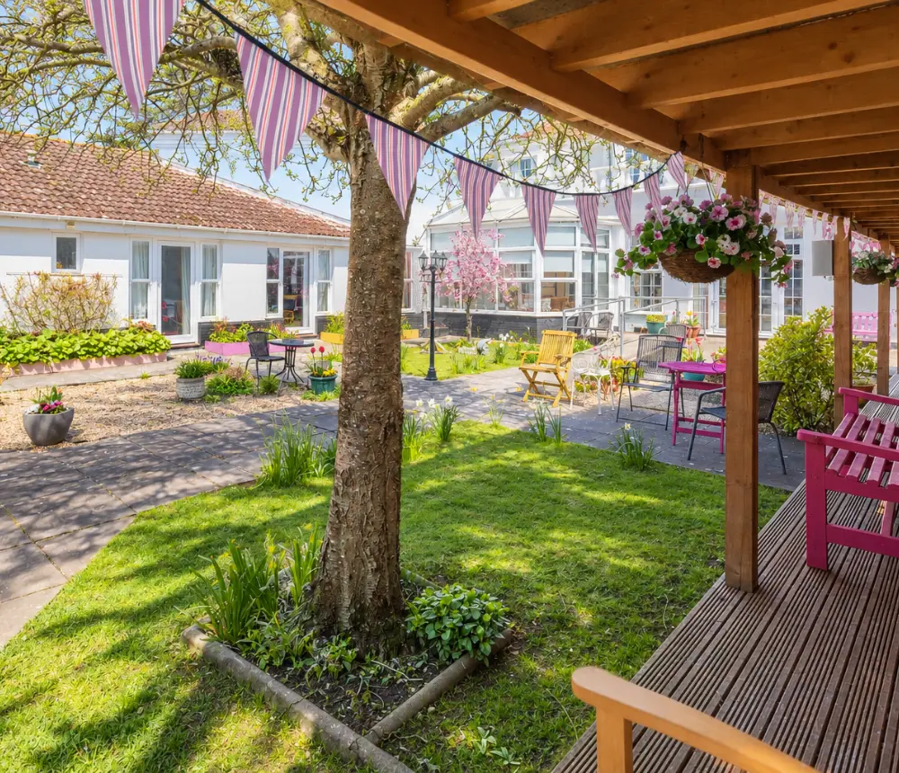 Sheltered garden decking and outdoor seating at The White House care home in Beccles.