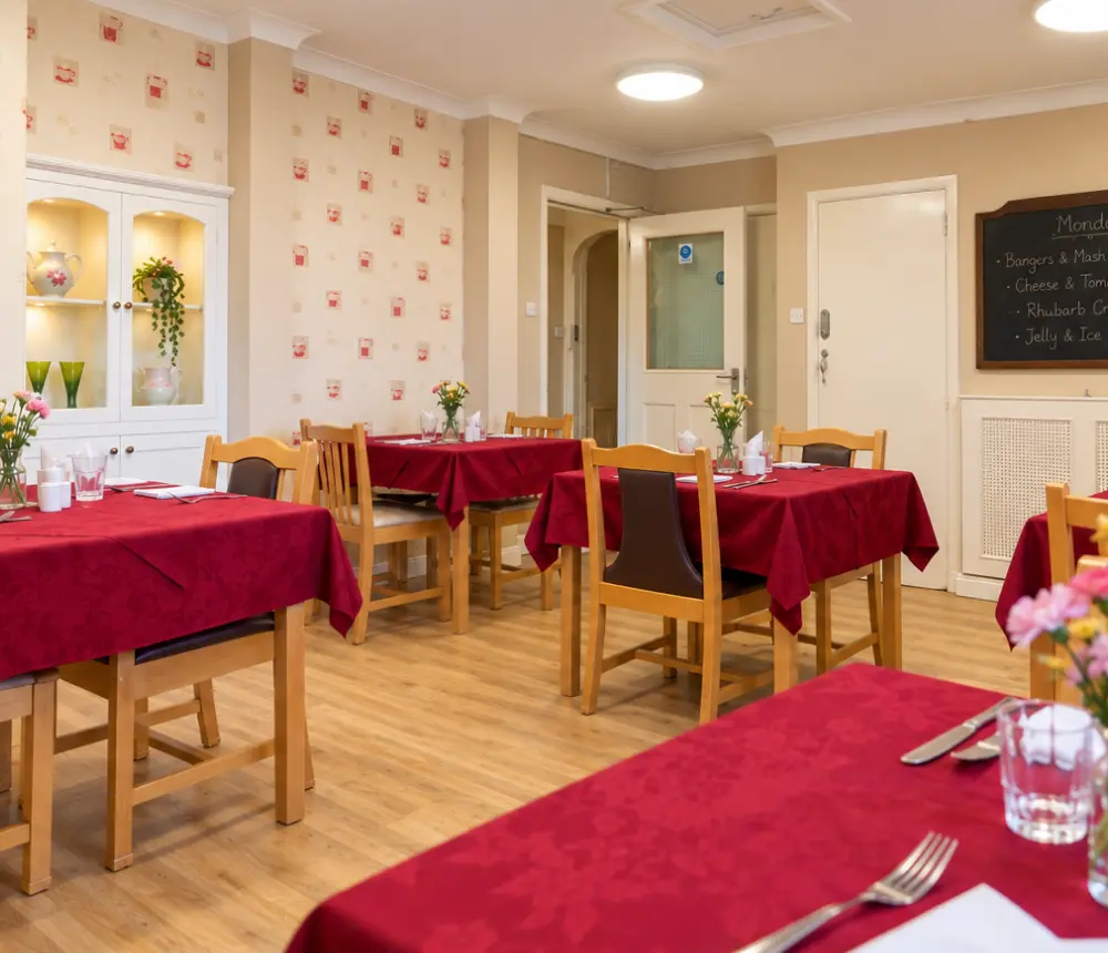 Welcoming dining room with neatly laid tables at The White House care home in Beccles.