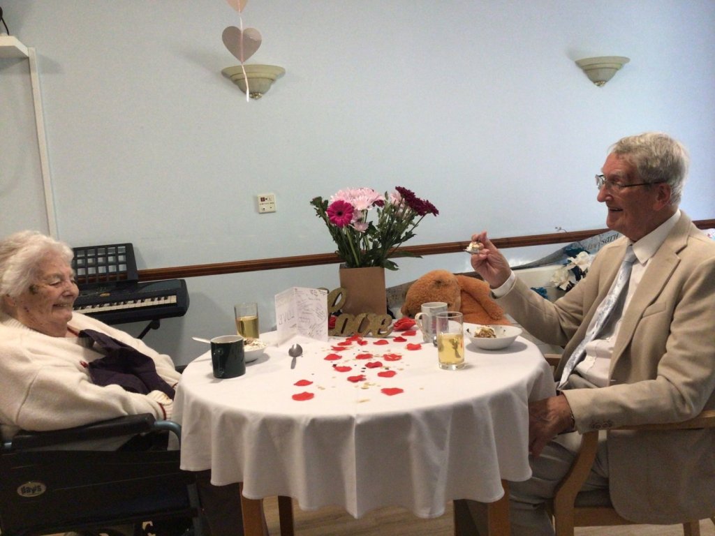Janet and Norman sitting at a table enjoying a celebratory lunch at Blandford Grange care home