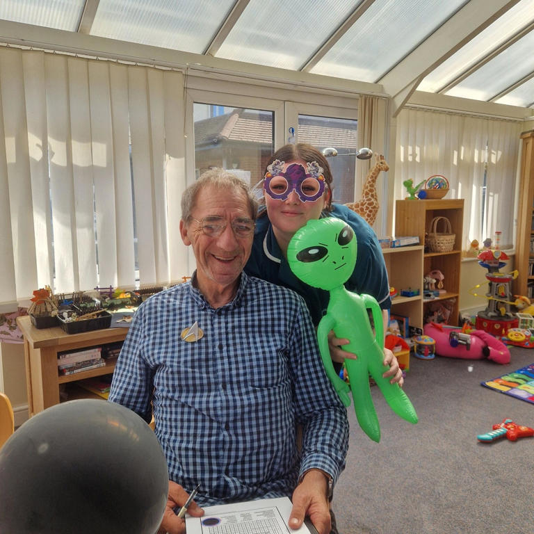 Resident at Bedhampton Court Care Home posing with inflatable Pete the alien during Star Trek Day celebrations.