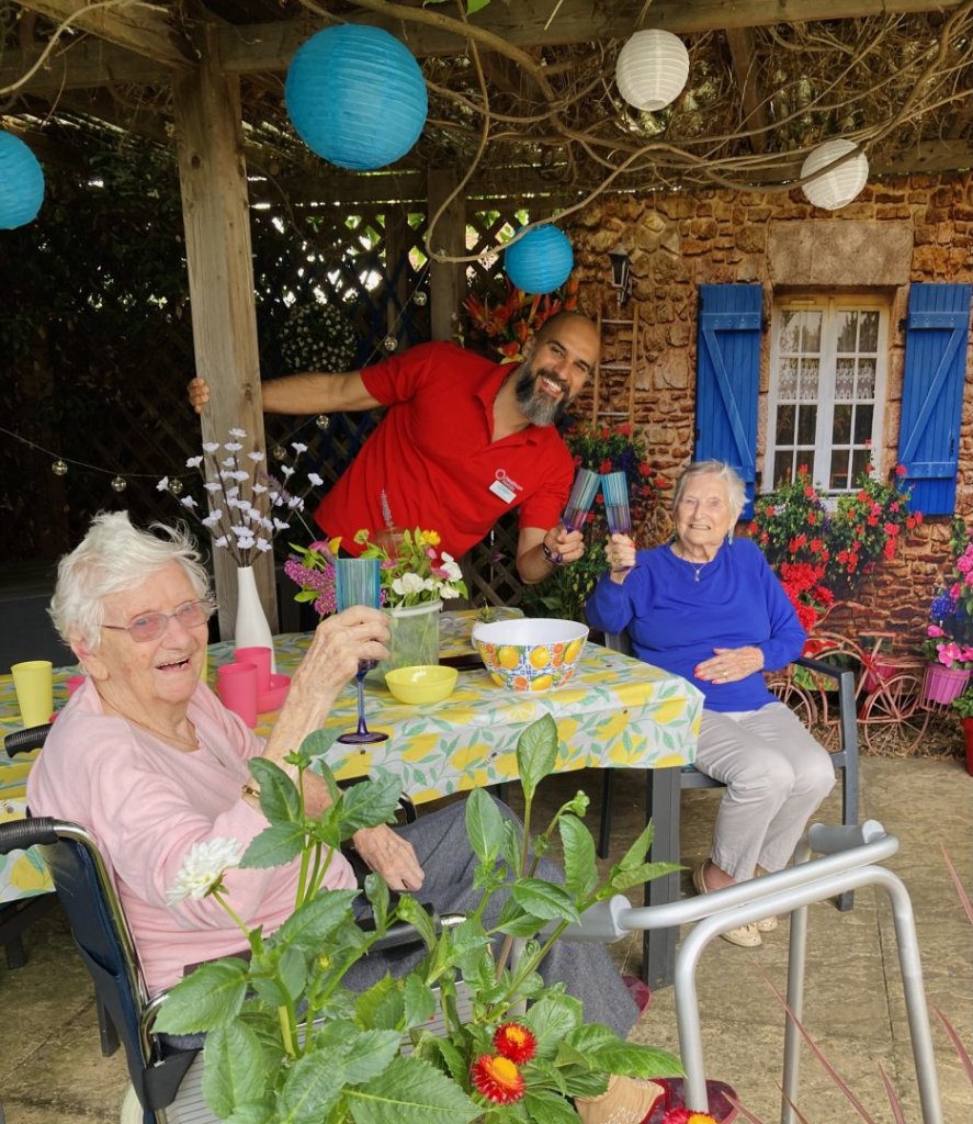 Mediterranean-themed garden display at Sandown Park Care Home featuring colourful plants, terracotta pots, and creative decorations made by residents