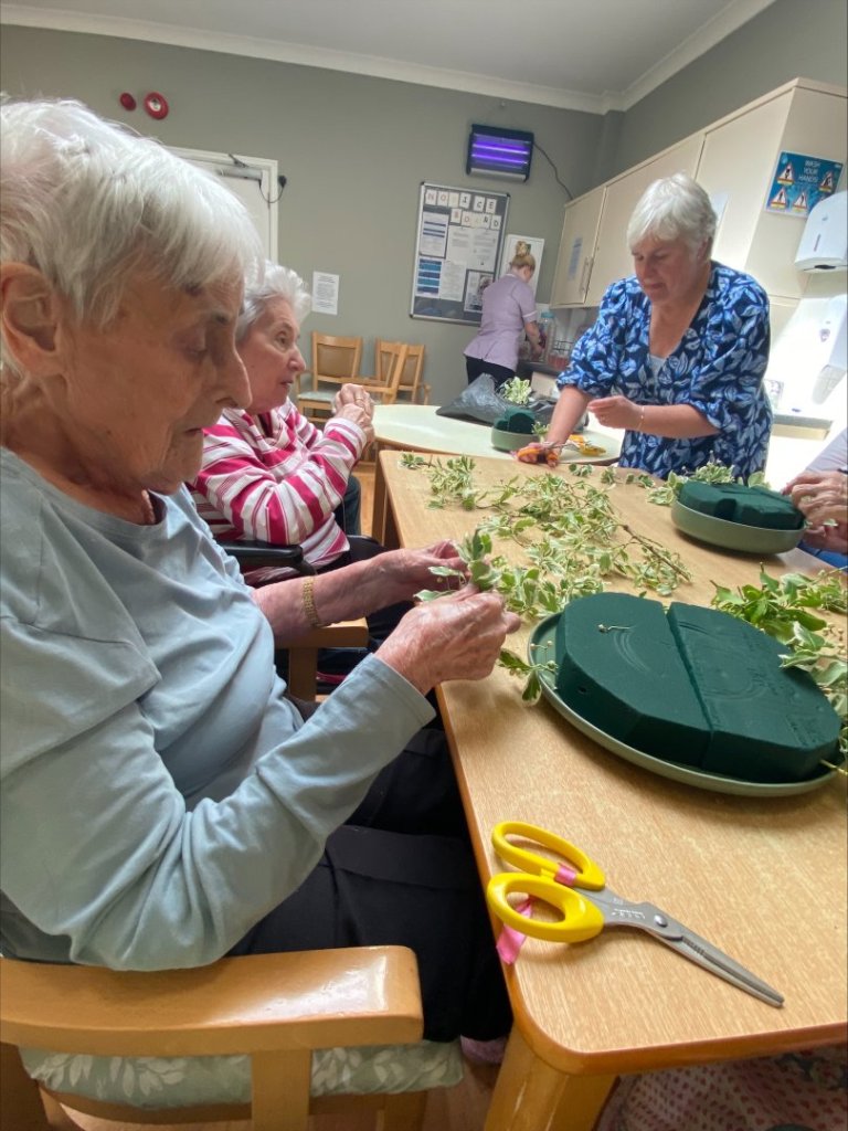 “Residents at Shipdham Manor carefully arranging flowers as part of their award-winning InBloom project