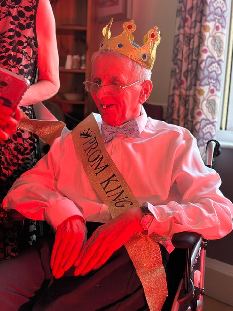 Prom King at Oaktree Care Home wearing a crown and smiling during the Red Carpet Prom celebration