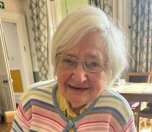 Retired nurse at Uvedale Hall, photographed seated comfortably and smiling during an interview.