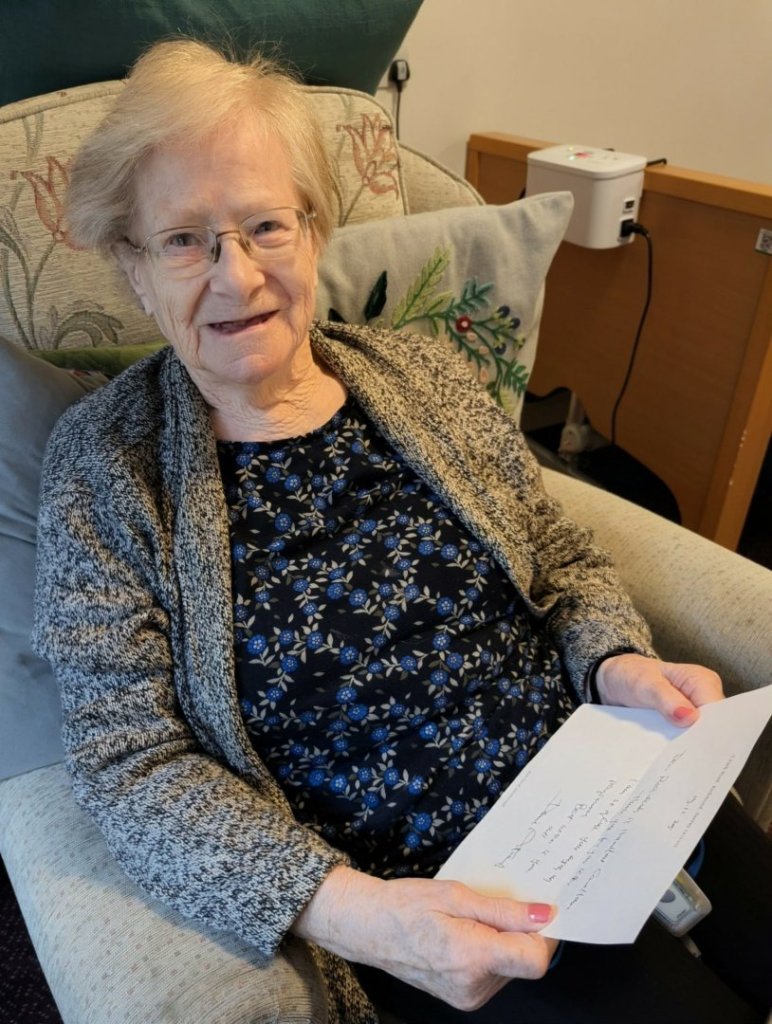 Resident at Handford House care home in Ipswich holding a handwritten letter from Sir David Attenborough