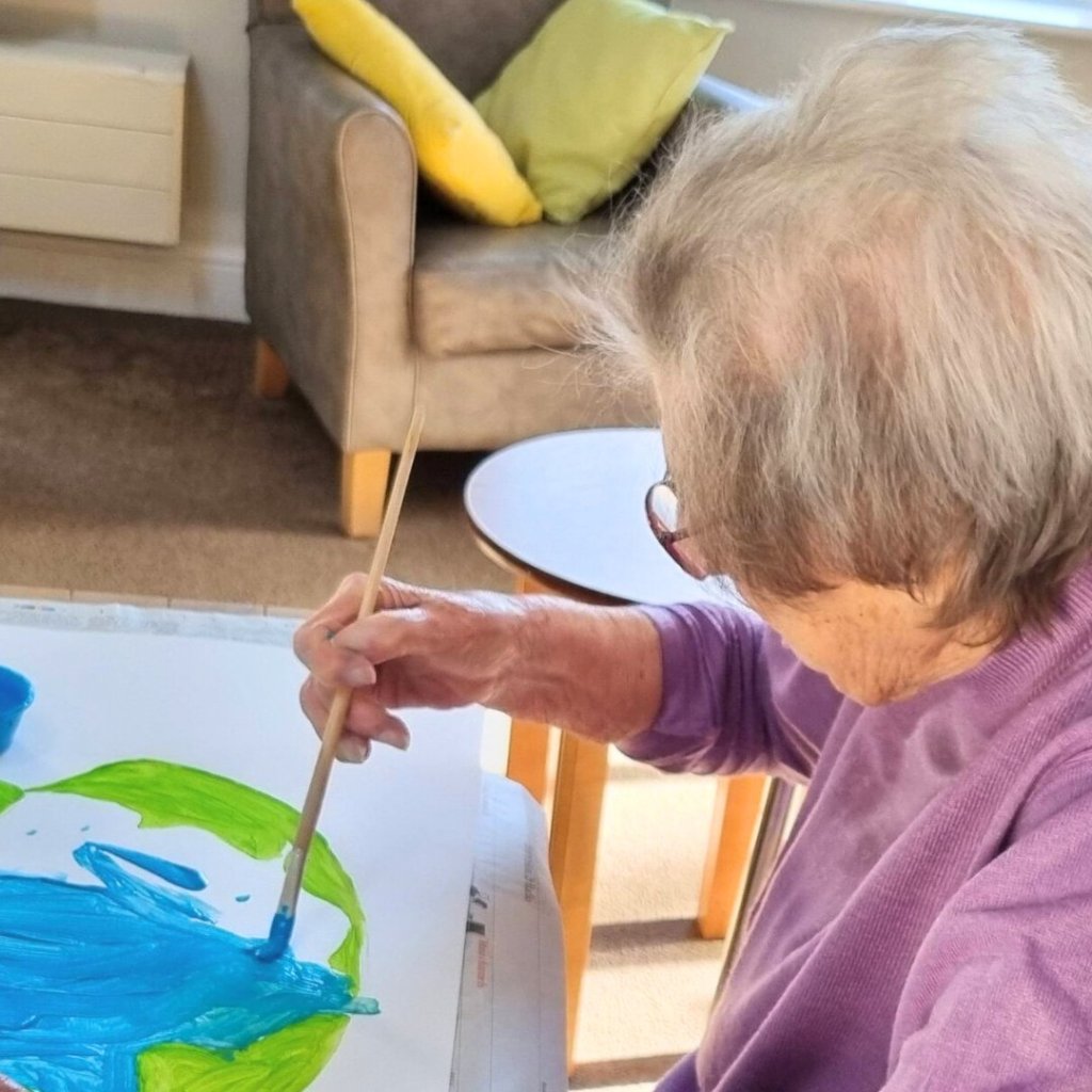 Resident Monica painting the Earth for the World Wildlife Day collage at Aldringham Court.