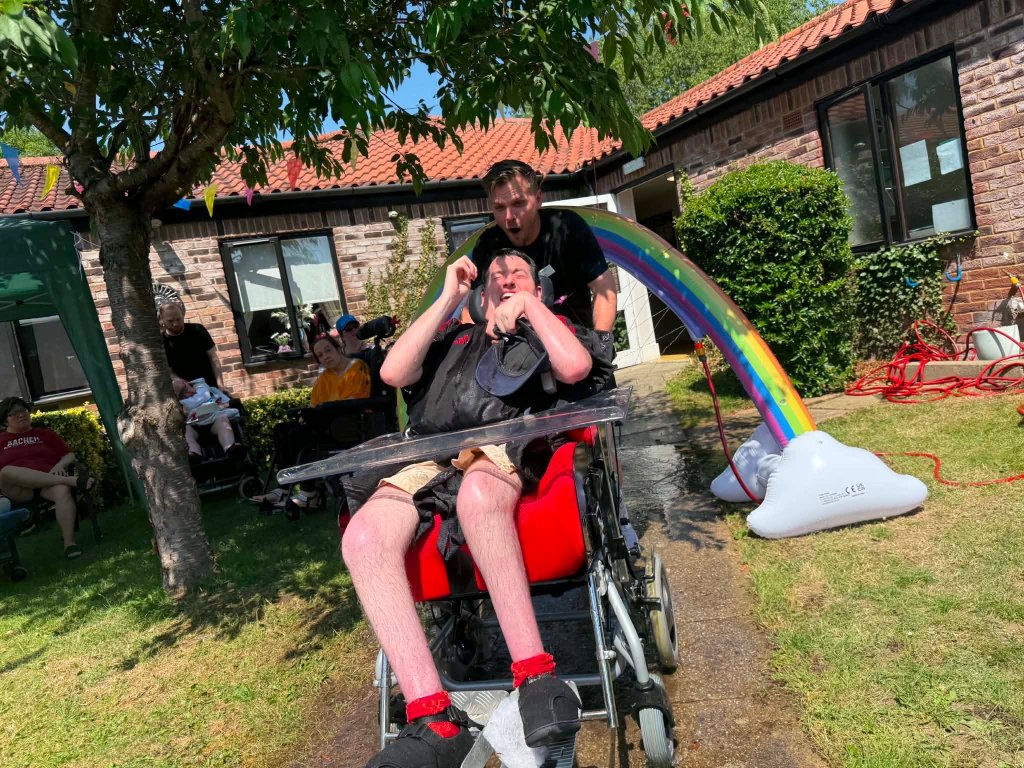 Residents at Meadow House in Swaffham taking part in a rainbow wheelchair wash during hot weather in the care home garden